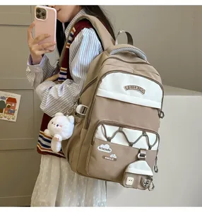 Vista detallada de mochila casual con múltiples bolsillos y colgante de felpa para la escuela.