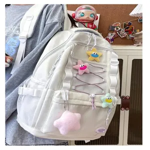 Zaino bianco multitasche con simpatici ciondoli in peluche a stella per la scuola.