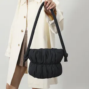Detalle del bolso de hombro negro acolchado, diseño suave de nailon muy moderno y elegante.