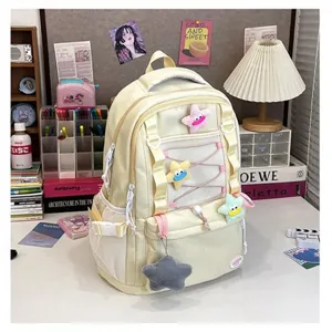 Dettaglio dello zaino giallo multitasche con graziosi ciondoli a stella in peluche morbido.