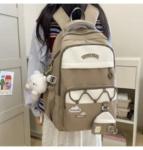Vista detallada de la mochila de estudiante beige con múltiples bolsillos y bonitos peluches.