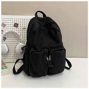 Detail view of minimalist black denim backpack with front pockets, vintage Japanese style.
