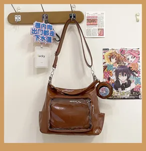 Detail shot of brown PU leather ita bag, clear front pocket for pins, daily shoulder bag.