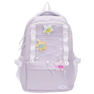 Vista dettagliata dello zaino viola con ciondoli stella in peluche, tasche rete e bretelle.