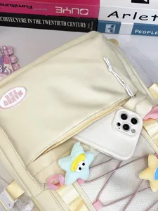 Primo piano dettagliato dello zaino casual multitasche con grazioso ciondolo in peluche.