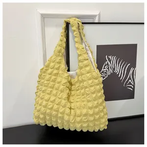 Yellow puckered texture shoulder bag detail, minimalist bubble fabric design tote purse.
