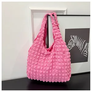 Pink bubble textured shoulder bag detail shot, stylish cloud vest handbag close-up view.