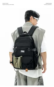 Detail view of tactical multi-pocket backpack, durable black fabric for outdoor travel use.