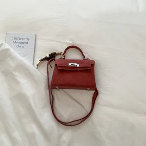 Red stylish top handle shoulder bag with classic lock closure for women daily wear and chic look.