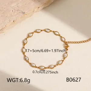 Detail shot of gold stainless steel station bracelet with white oval crystal stones.
