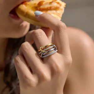 Detailed view of a trendy multi-band interlocking stackable ring set worn on finger.