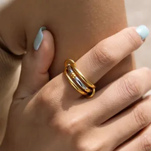 Detailed close-up shot of a chic multi-layer interlocking gold and silver tone ring.