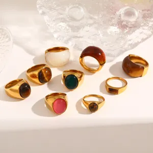 Detailed shot of trendy stainless steel rings set with natural stones and resin inlays.