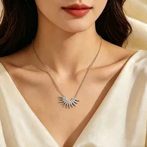 Gros plan détaillé du collier minimaliste en acier titane avec pendentif soleil sur le cou.