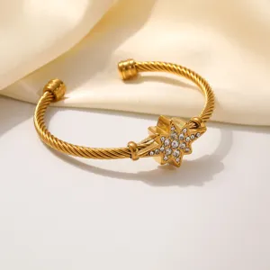 Detailopname van de gouden roestvrijstalen kabelarmband met stralende kristallen ster.
