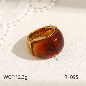 Detailed view of chunky stainless steel amber resin ring, minimalist luxury fashion jewelry.