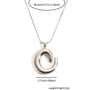 Stainless steel necklace pendant close-up, geometric design detail showing metal texture and size.