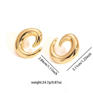 Gold sculptural statement earrings closeup, featuring unique asymmetric curves and dimensions.