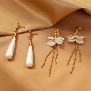Close-up detail of stainless steel waterdrop pearl and flower tassel earrings for women