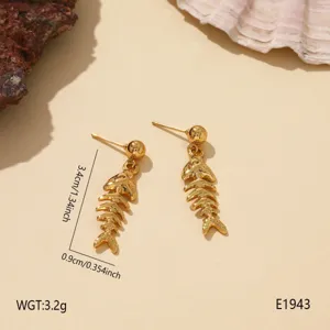 Gold fish bone dangle earrings close-up, featuring detailed metallic texture for summer.