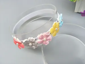 Gros plan détaillé du bandeau bébé fleurs en tissu coloré avec des perles décoratives