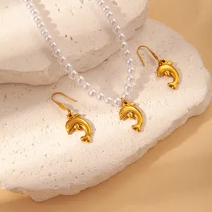 Gold dolphin pendant necklace and matching earrings detailed shot, summer ocean style jewelry.