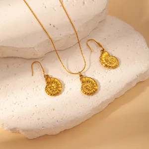 Close-up of gold stainless steel shell pendant necklace and matching earrings set detail.