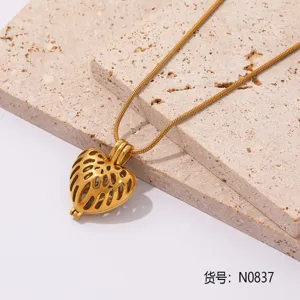 Primer plano detallado de un collar con colgante de corazón dorado sobre soportes de piedra.