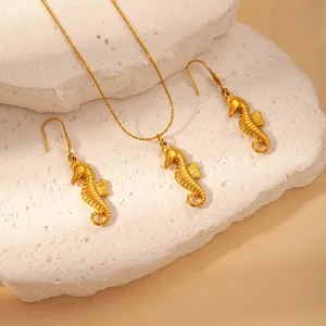 Close up of gold stainless steel seahorse pendant necklace and matching earrings set detail.