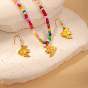 Colorful beaded necklace and gold fish earrings set, summer ocean style jewelry detail.