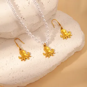 Close-up detail of gold octopus pendant pearl necklace and matching earrings, summer ocean jewelry.
