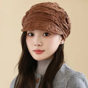 Detailed view of the brown lace duckbill cap worn by model, showcasing fine texture and design.
