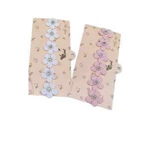Detail van de babyhaarband met zeven handgemaakte strass bloemen voor schattige haarmode.