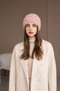 Dettaglio berretto in maglia rosa con comoda trama di lana e delicate decorazioni di perle.