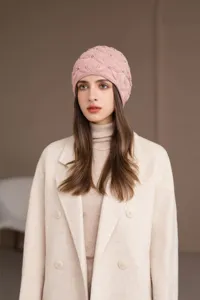 Primo piano di un accogliente berretto in maglia rosa con delicate perline, dettaglio moda invernale