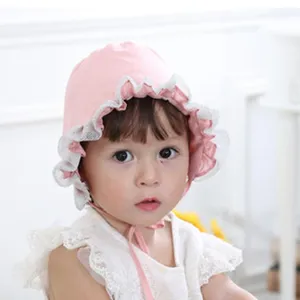 Leuke roze baby zonnehoed met witte kantafwerking, gedetailleerd overzicht van zomerhoofddeksel.