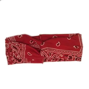 Red paisley print twisted fabric headband detail shot, retro boho hair accessory.