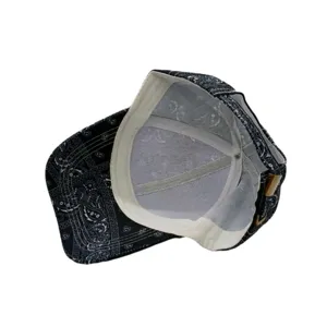 Vue détaillée de la doublure intérieure et de la boucle en métal d'une casquette noir et blanc.