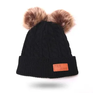 Black knit winter beanie for kids with cute dual faux fur pom poms and stylish leather patch.