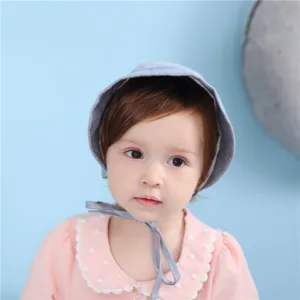 Nahaufnahme Detail der süßen Baby-Haube mit Bändern, weicher Baumwollstoff, sehr schick.