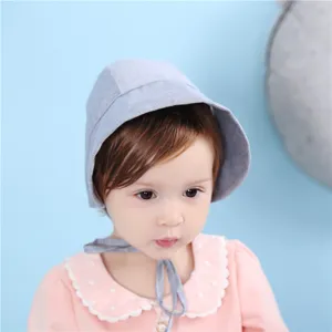 Detailansicht des süßen Babys mit weicher Baumwollhaube und praktischen Bindebändern.