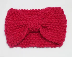Close-up view of magenta knitted headband with bow detail, warm wool texture for autumn winter.