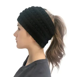 Dettaglio laterale di un berretto nero in maglia con apertura per coda di cavallo.