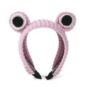 Cute pink crochet frog eye headband detail view, soft knitted plush hair hoop for daily wear.