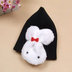 Detailed view of black knitted baby hat featuring a cute white plush rabbit applique.