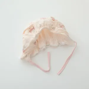 Detail view of infant pink cotton gauze bonnet featuring cute bunny prints and delicate lace trim.