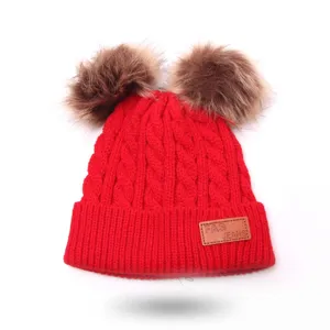 Cute kids double pom-pom knit beanie hat in vibrant red, warm and stylish winter accessory.