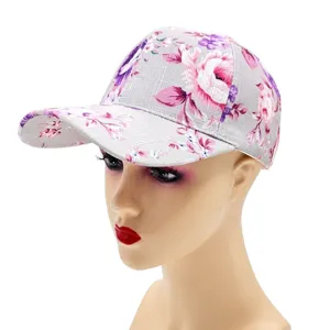 Close-up of a stylish floral print baseball cap with grey background and pink flowers.