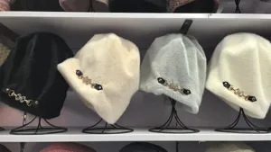Detailansicht verdickter Damen Plüsch Winter Mütze mit elegantem Metall Schnallen Anhänger.