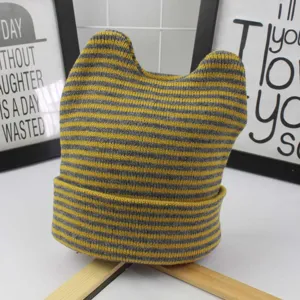 Close-up detail of yellow and grey striped baby cat ear knit hat with folded brim.